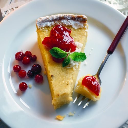 Halloween sweet pumpking cake with cranberry cream and fork on a plate. Traditional holiday food